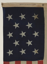 ANTIQUE AMERICAN FLAG WITH 13 STARS, A U.S. NAVY SMALL BOAT ENSIGN WITH AN EXTREMELY RARE BLOCK-PRINTED MARK FROM THE BOSTON NAVY YARD, 1863-1866