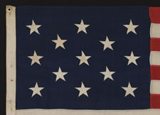 ANTIQUE AMERICAN FLAG WITH 13 STARS IN A 3-2-3-2-3 PATTERN AND AN ELONGATED PROFILE, A SMALL-SCALE FLAG OF THE 1895-1926 ERA