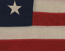 ANTIQUE AMERICAN FLAG WITH 13 STARS IN A 3-2-3-2-3 PATTERN AND AN ELONGATED PROFILE, A SMALL-SCALE FLAG OF THE 1895-1926 ERA