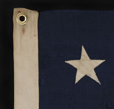 ANTIQUE AMERICAN FLAG WITH 13 STARS IN A 3-2-3-2-3 PATTERN AND AN ELONGATED PROFILE, A SMALL-SCALE FLAG OF THE 1895-1926 ERA