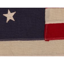 ANTIQUE AMERICAN PRIVATE YACHT FLAG (ENSIGN) WITH 13 STARS SURROUNDING A CANTED ANCHOR, CIRCA 1910 – 1920’s