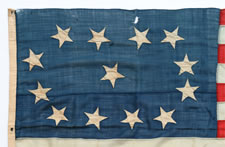 EARLY 13 STAR SHIP'S FLAG WITH A LOPSIDED OVAL VARIATION OF THE 3RD MARYLAND PATTERN, CA 1840-1860, ENTIRELY HAND-SEWN, A BEAUTIFUL EXAMPLE