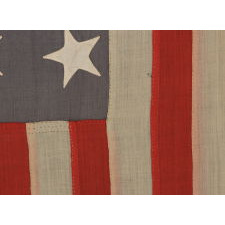 ENTIRELY HAND-SEWN, 13 STAR, U.S. NAVY SMALL BOAT ENSIGN WITH A DUSTY BLUE CANTON, SIGNED AND DATED, 1889