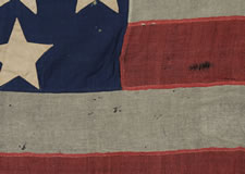 ENTIRELY HAND-SEWN 34 STAR FLAG OF THE CIVIL WAR PERIOD WITH A GREAT EARLY APPEARANCE, A WIDE LINEN SLEEVE, AND A VERY UNUSUAL ARRANGEMENT OF UNCOMMONLY LARGE STARS, 1861-63