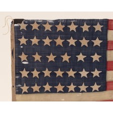 ENTIRELY HAND-SEWN 34 STAR FLAG OF THE CIVIL WAR PERIOD, WITH HAND-SEWN, SINGLE-APPLIQUED STARS AND ENDEARING WEAR FROM LONG-TERM USE, REFLECTS KANSAS STATEHOOD, 1861-1863