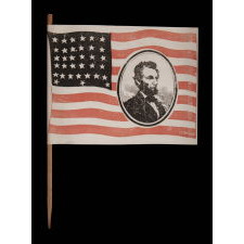 EXTREMELY RARE ABRAHAM LINCOLN MOURNING FLAG, WITH HIS PORTRAIT IN THE STRIPED FIELD, ON ITS ORIGINAL STAFF; PRINTED ON PAPER, SIGNED “LYBRAND,” 1865