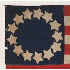 HOMEMADE 13 STAR FLAG OF THE LATE 1890's -1920's ERA, WITH WONDERFULLY FOLKY STARS THAT PRACTICALLY TOUCH ONE-ANOTHER, ARRANGED IN CIRCULAR WREATH PATTERN OFTEN ATTRIBUTED TO BETSY ROSS, AND ITS CANTON RESTING ON THE WAR STRIPE; POSSIBLY MADE DURING WWI (