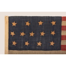 ONE OF THE EARLIEST 13 STAR ANTIQUE AMERICAN FLAGS THAT ONE WILL EVER ENCOUNTER, CIRCA 1820's-1840's, ENTIRELY HAND-SEWN, WITH SINGLE-APPLIQUÉD STARS IN A 4-5-4 ARRANGEMENT, TINY IN SCALE AMONG ITS COUNTERPARTS