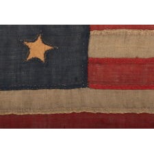 ONE OF THE EARLIEST 13 STAR ANTIQUE AMERICAN FLAGS THAT ONE WILL EVER ENCOUNTER, CIRCA 1820's-1840's, ENTIRELY HAND-SEWN, WITH SINGLE-APPLIQUÉD STARS IN A 4-5-4 ARRANGEMENT, TINY IN SCALE AMONG ITS COUNTERPARTS