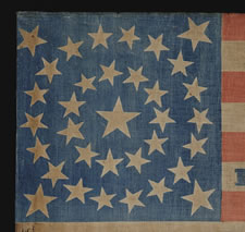 ONE OF THE LARGEST KNOWN PARADE FLAGS MADE FOR THE 1864 CAMPAIGN OF ABRAHAM LINCOLN & ANDREW JOHNSON, 34 STARS IN A MEDALLION CONFIGURATION ON A CHROME BLUE CANTON WITH MATCHING BLUE TEXT, AN EXTRAORDINARY EXAMPLE