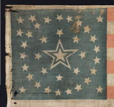 ONE-OF-A-KIND AMONG KNOWN EXAMPLES:   36 STAR PARADE FLAG WITH A MEDALLION CONFIGURATION THAT HAS A HUGE,  HALOED CENTER STAR, ONE STAR FLANKING IN EACH OF THREE CORNERS, AND A TRIO OF STARS IN ONE CORNER, CIVIL WAR ERA, NEVADA STATEHOOD, 1864-67: