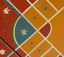 ORANGE PARCHEESI BOARD WITH WHIMSICAL MEDALLIONS, POLKA DOTS, & SNOWFLAKE STARS, circa 1885