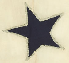 PRIVATE OWNER'S YACHT BURGEE, ENTIRELY HAND-SEWN, WITH 13 RED STARS ARRANGED IN A WREATH, SURROUNDING A SINGLE, LARGE, NAVY BLUE CENTER STAR, ALL ON A WHITE GROUND, CA 1860-1880, SIGNED ON THE HOIST "M. HEMINGWAY"