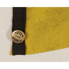 TRIANGULAR, YELLOW, SUFFRAGETTE PENNANT WITH VIOLET "VOTES FOR WOMEN" TEXT, A BLACK BINDING & TIES, AND A GOLD PIN-BACK AFFIXED TO THE HOIST END, CA 1910-1920