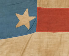 A WELL-LOVED, CARRIED, AND MENDED 36 STAR FLAG THAT PROBABLY STARTED LIFE WITH 33 STARS, ARRANGED IN A "GREAT STAR" PATTERN, CIVIL WAR PERIOD, GREAT SMALL SIZE AND CORNFLOWER BLUE COLOR, 1861-65