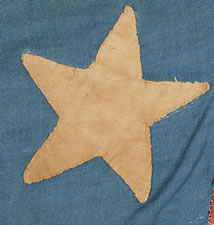 A WELL-LOVED, CARRIED, AND MENDED 36 STAR FLAG THAT PROBABLY STARTED LIFE WITH 33 STARS, ARRANGED IN A "GREAT STAR" PATTERN, CIVIL WAR PERIOD, GREAT SMALL SIZE AND CORNFLOWER BLUE COLOR, 1861-65