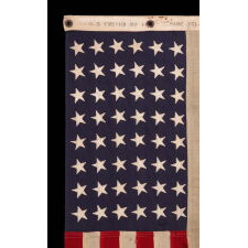 AMERICAN FLAG, 48 STARS, A U.S. NAVY SMALL BOAT ENSIGN, MADE IN SEPTEMBER OF 1943, DURING WWII, AT MARE ISLAND, CALIFORNIA, HEADQUARTERS OF THE PACIFIC FLEET, WITH ENDEARING WEAR FROM OBVIOUS LONG-TERM USE