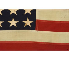 WWII BATTLE FLAG FROM THE U.S.S. FLINT WITH 48 STARS, BROUGHT HOME BY FIREMAN 2ND CLASS F. W. PERRINE, EMBROIDERED WITH HIS NAME, THE SHIP'S NAME, AND DATES OF SERVICE