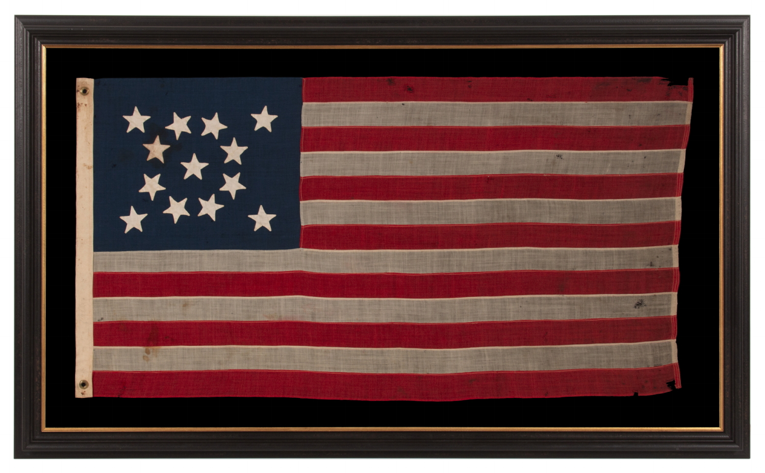 13 STAR ANTIQUE AMERICAN FLAG WITH A MEDALLION CONFIGURATION OF HAND-SEWN STARS AND A BEAUTIFUL, ELONGATED PROFILE, MADE IN THE ERA OF THE 1876 CENTENNIAL OF AMERICAN INDEPENDENCE, IN AN UNCOMMONLY SMALL SIZE AMONG ITS COUNTERPARTS OF THE PERIOD WITH SEWN CONSTRUCTION