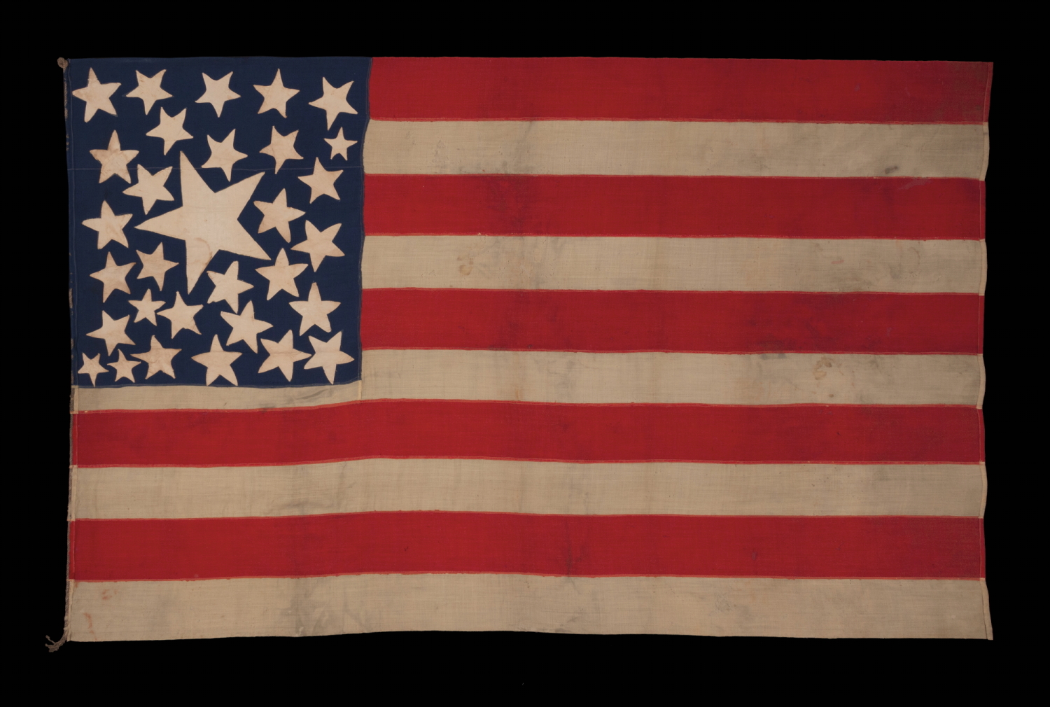 31 STARS ON AN EXTRAORDINARY ANTIQUE AMERICAN FLAG WITH A RANDOM CONSTELLATION, IN VARIOUS SHAPES AND SIZES, CLUSTERED ABOUT AN ENORMOUS CENTER STAR, WITH A COMPLEMENT OF 10 STRIPES; A MASTERPIECE OF EARLY AMERICAN FLAG-MAKING, CALIFORNIA STATEHOOD, 1850-1858