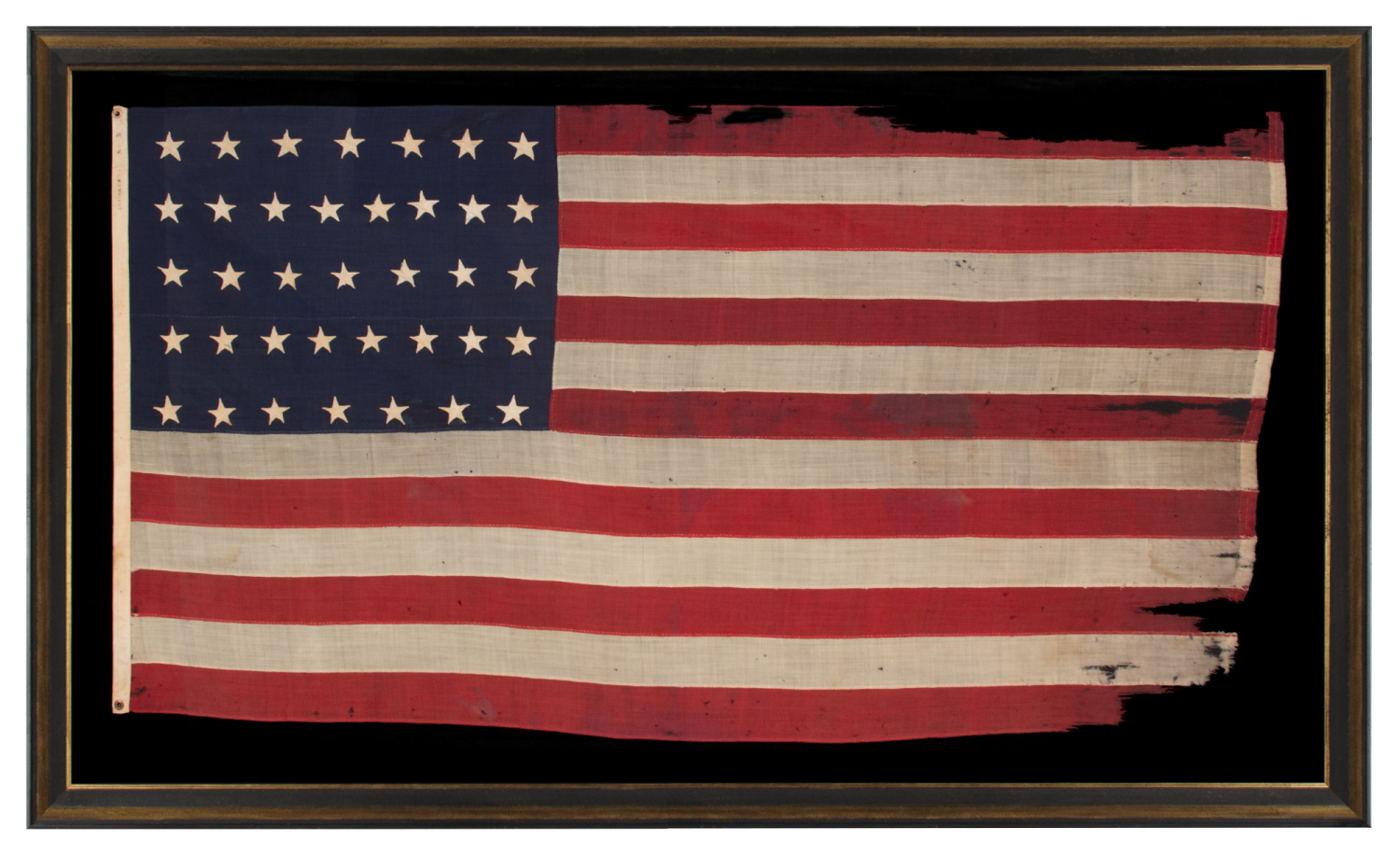 37 STAR ANTIQUE AMERICAN FLAG, ENTIRELY HAND-SEWN THROUGHOUT, WITH JUSTIFIED ROWS OF SINGLE-APPLIQUED STARS, MADE & SIGNED BY THE ANNIN COMPANY IN NEW YORK CITY, WITH SIGNIFICANT WEAR FROM EXTENDED USE; REFLECTS THE ERA WHEN NEBRASKA WAS THE MOST RECENT STATE TO JOIN THE UNION, 1867-1876