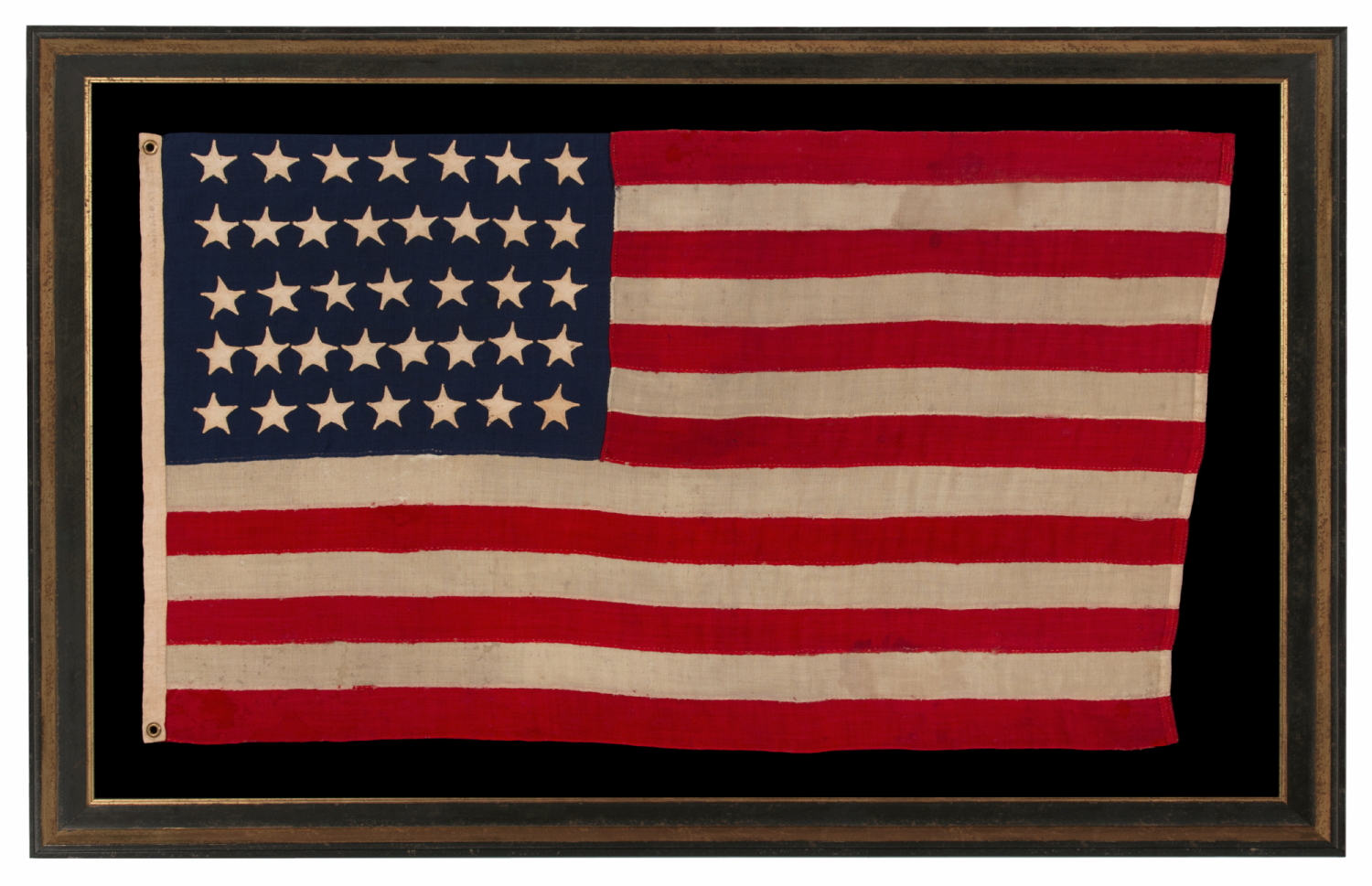 37 STAR ANTIQUE AMERICAN FLAG, MADE & SIGNED BY THE ANNIN COMPANY IN NEW YORK CITY, ENTIRELY HAND-SEWN AND WITH SINGLE-APPLIQUÉD STARS, IN A SMALL AND VERY DESIRABLE SCALE AMONG THOSE WITH PIECED-AND-SEWN CONSTRUCTION; REFLECTS THE ERA WHEN NEBRASKA WAS THE MOST RECENT STATE TO JOIN THE UNION, 1867-1876