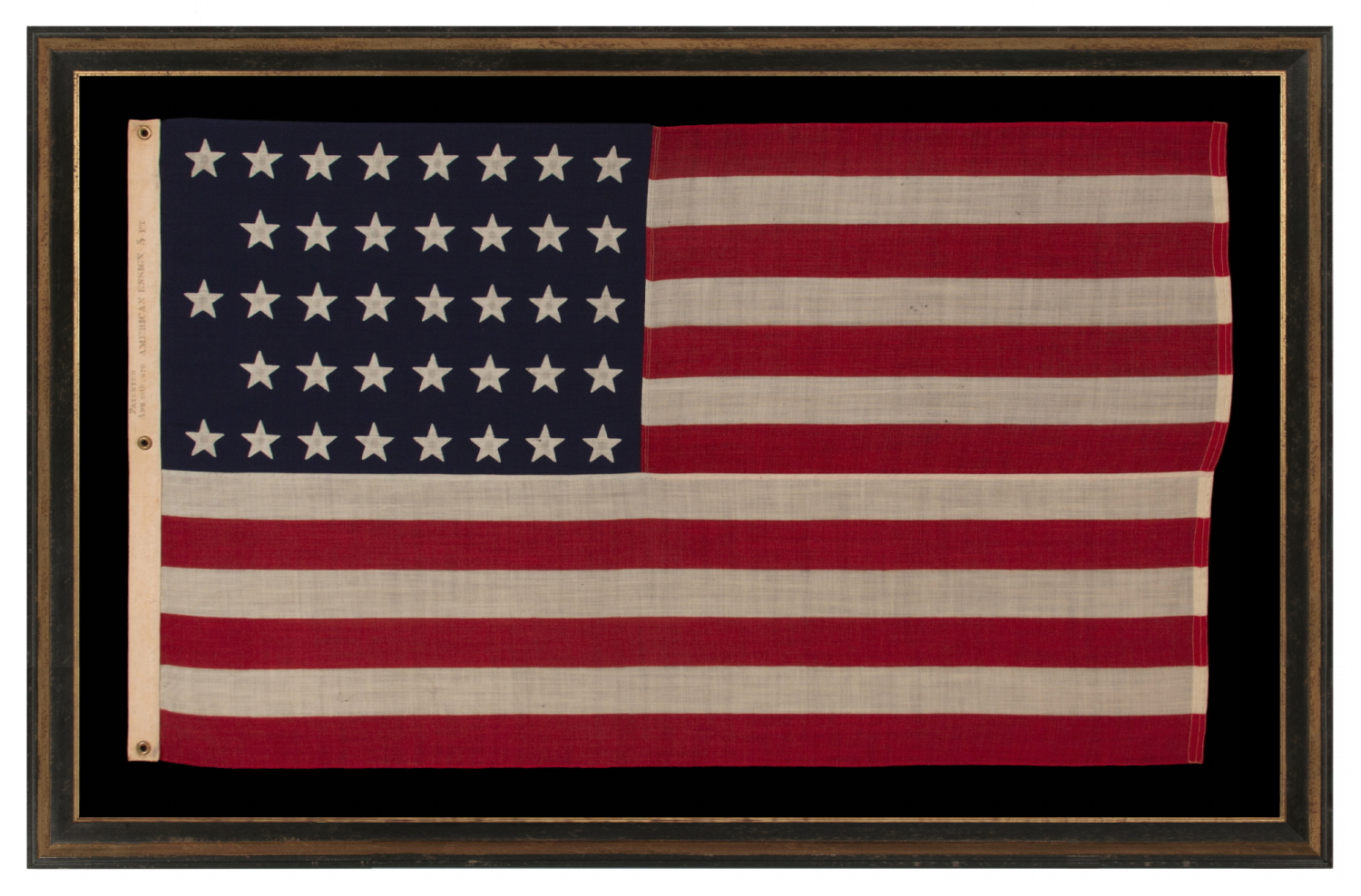38 STAR ANTIQUE AMERICAN FLAG WITH A NOTCHED CONFIGURATION, MADE BY THE U.S. BUNTING COMPANY IN LOWELL, MASSACHUSETTS, REFLECTS THE ERA OF COLORADO STATEHOOD, circa 1876-1889