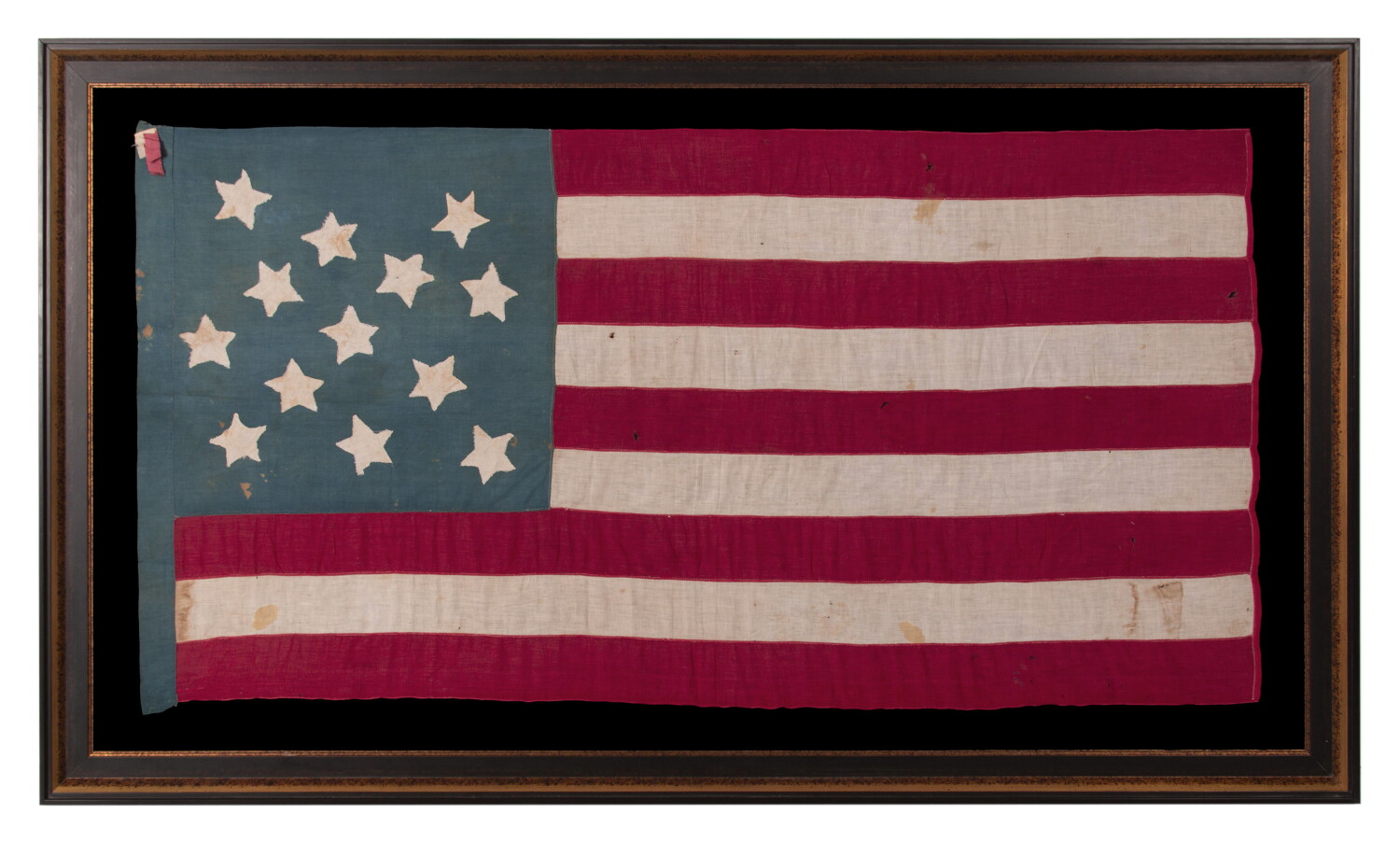 13 STAR ANTIQUE AMERICAN FLAG OF THE CIVIL WAR PERIOD (1861-1865), HOMEMADE AND ENTIRELY HAND-SEWN, WITH ITS CANTON RESTING ON THE WAR STRIPE, AND WITH 9 STRIPES TO REFLECT THE OMISSION OF NORTH & SOUTH CAROLINA, GEORGIA, AND VIRGINIA, THE 4 SLAVE STATES AMONG THE ORIGINAL 13 COLONIES THAT SECEDED FROM THE UNION