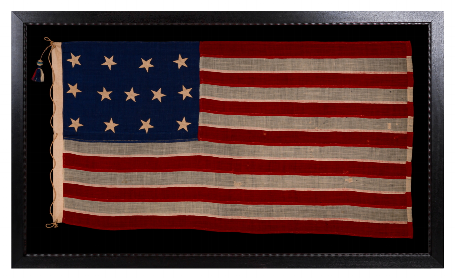 13 STARS IN THE 4-5-4 PATTERN ON AN ENTIRELY HAND-SEWN FLAG OF THE CIVIL WAR PERIOD, OR JUST PRIOR, circa 1854-1864, WITH HEMP ROPE AND A SINGLE TASSEL; PROBABLY A U.S. NAVY SMALL BOAT ENSIGN; SIGNED “JENNIE B. SEAVER,” NEWTON, MASSACHUSETTS; LIKELY OF BOSTON NAVY YARD ORIGIN