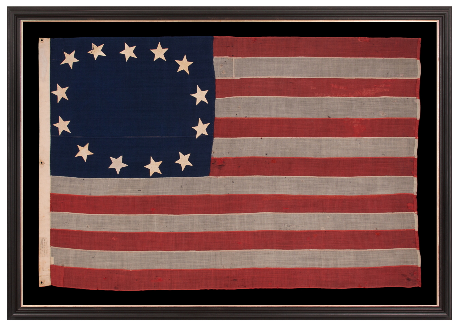 13 STARS IN A CRUDE SINGLE WREATH, REMINISCENT OF THE BETSY ROSS PATTERN, BUT RENDERED AS MORE OF AN OVAL; AN ANTIQUE AMERICAN FLAG MADE OF THE CIVIL WAR ERA, WITH AN EXTREMELY RARE & STAR CONFIGURATION FOR THE PERIOD; SIGNED BY THE SHOP OF PROMINENT FLAG-MAKER WILLIAM SCHEIBLE OF PHILADELPHIA, SITUATED JUST TWO BLOCKS FROM BOTH INDEPENDENCE HALL & THE BETSY ROSS HOUSE