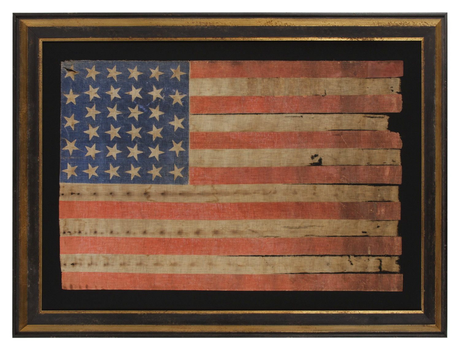 34 STARS ON AN ANTIQUE AMERICAN PARADE FLAG OF THE CIVIL WAR PERIOD, LARGE AMONG ITS COUNTERPARTS, WITH EXTENSIVE AND ENDEARING WEAR FROM OBVIOUS LONG-TERM USE; REFLECTS THE ERA WHEN KANSAS WAS THE MOST RECENT STATE TO JOIN THE UNION, 1861-63