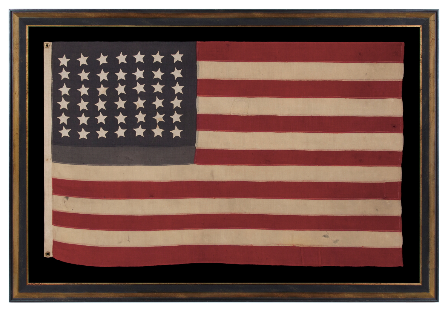 42 HAND-SEWN STARS ON AN ANTIQUE AMERICAN FLAG WITH A TWO-TONE, DUSTY BLUE CANTON, REFLECTS THE ADDITION OF WASHINGTON STATE, MONTANA, AND THE DAKOTAS, NEVER AN OFFICIAL STAR COUNT, circa 1889-1890