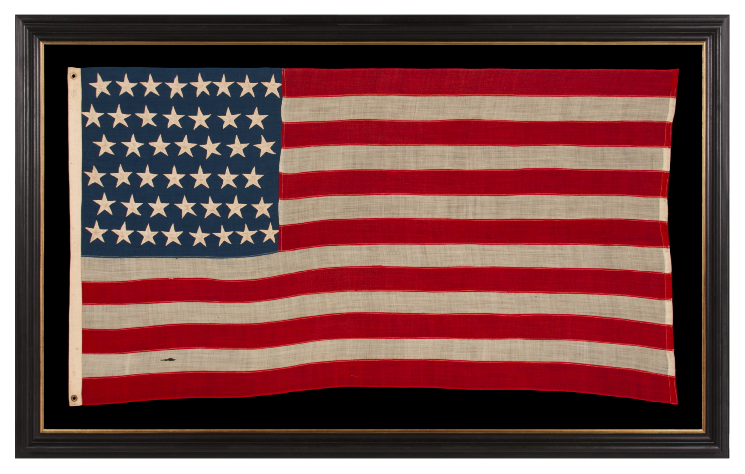 44 STARS IN ZIGZAGGING, STAGGERED ROWS, ON ANTIQUE AMERICAN FLAG WITH SOMEWHAT ELONGATED PROPORTIONS AND STRONG COLORS, MADE IN THE ERA WHEN WYOMING WAS THE MOST RECENT STATE TO JOIN THE UNION, 1890-1896