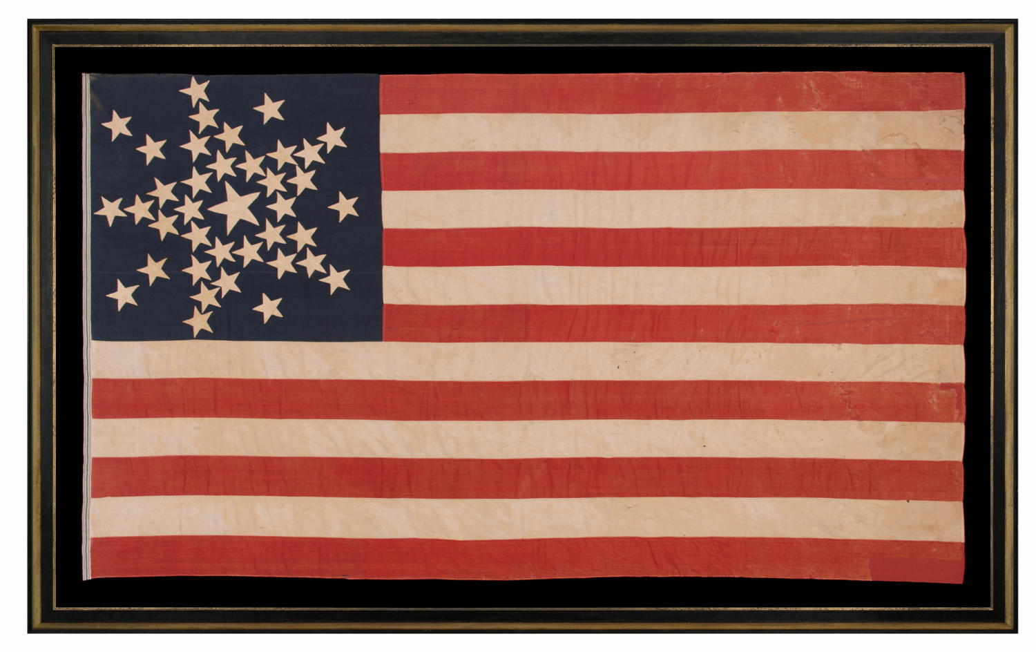SPECTACULAR ANTIQUE AMERICAN FLAG WITH 38 STARS, ARRANGED IN A RARE VARIANT OF THE "GREAT STAR" PATTERN THAT INCORPORATES STARS BETWEEN EACH ARM; MADE FOR THE 100th ANNIVERSARY OF AMERICAN INDEPENDENCE IN 1876, AMONG THE VERY BEST OF ALL KNOWN EXAMPLES IN THIS STAR COUNT, REFLECTS THE ADDITION OF COLORADO AS THE “CENTENNIAL STATE”