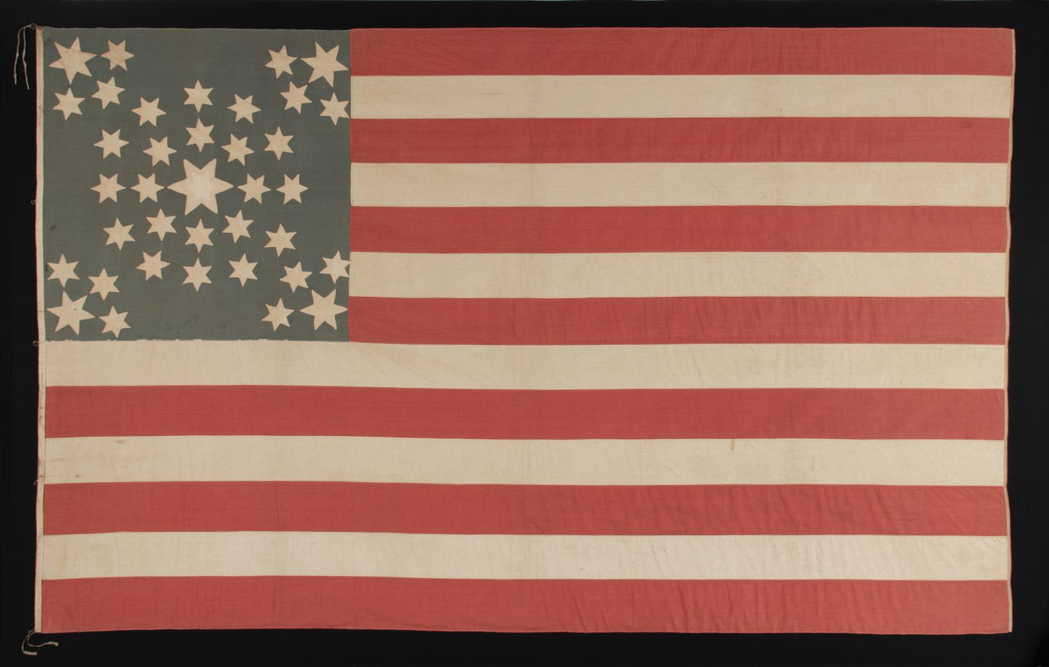 A MASTERPIECE AMONG KNOWN EXAMPLES: AMAZINGLY GRAPHIC FLAG WITH 37 SIX-POINTED STARS IN A SPECTACULAR DOUBLE-WREATH STYLE MEDALLION, POSSIBLY WITH A PRO-UNION MESSAGE, INSCRIBED WITH THE INTIALS "A.P." AND THE NAME "PURSEL." NEBRASKA STATEHOOD, 1867-1876