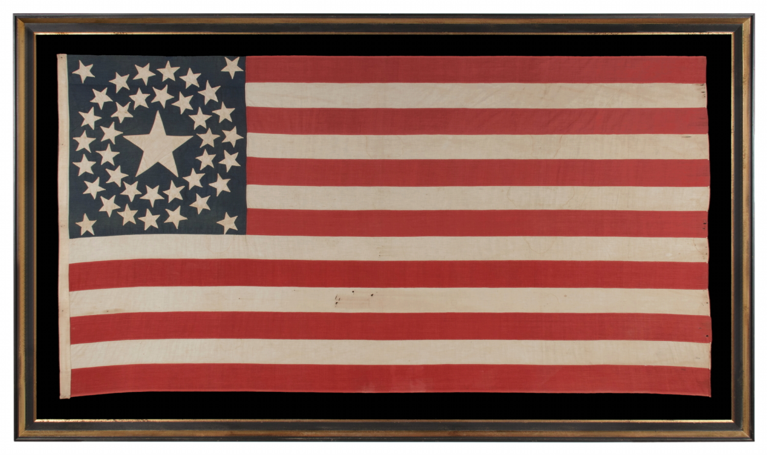 38 STAR ANTIQUE AMERICAN FLAG WITH A DOUBLE-WREATH CONFIGURATION THAT FEATURES AN ENORMOUS CENTER STAR, REFLECTS THE PERIOD OF COLORADO STATEHOOD, 1876-1889