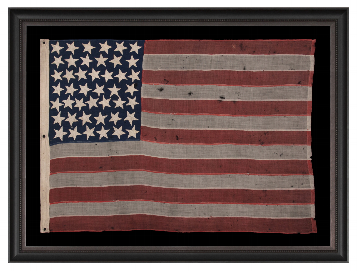 44 STAR ANTIQUE AMERICAN FLAG, WITH GREAT FOLK CHARACTERISTICS THAT INCLUDES A NARROW, VERTICALLY-ORIENTED CANTON AND EXPECIALLY LARGE STARS, ORIENTED IN ALL DIRECTIONS, THE ARMS OF WHICH ARE NECESSARILY INTERTWINED; WYOMING STATEHOOD, 1890-1896