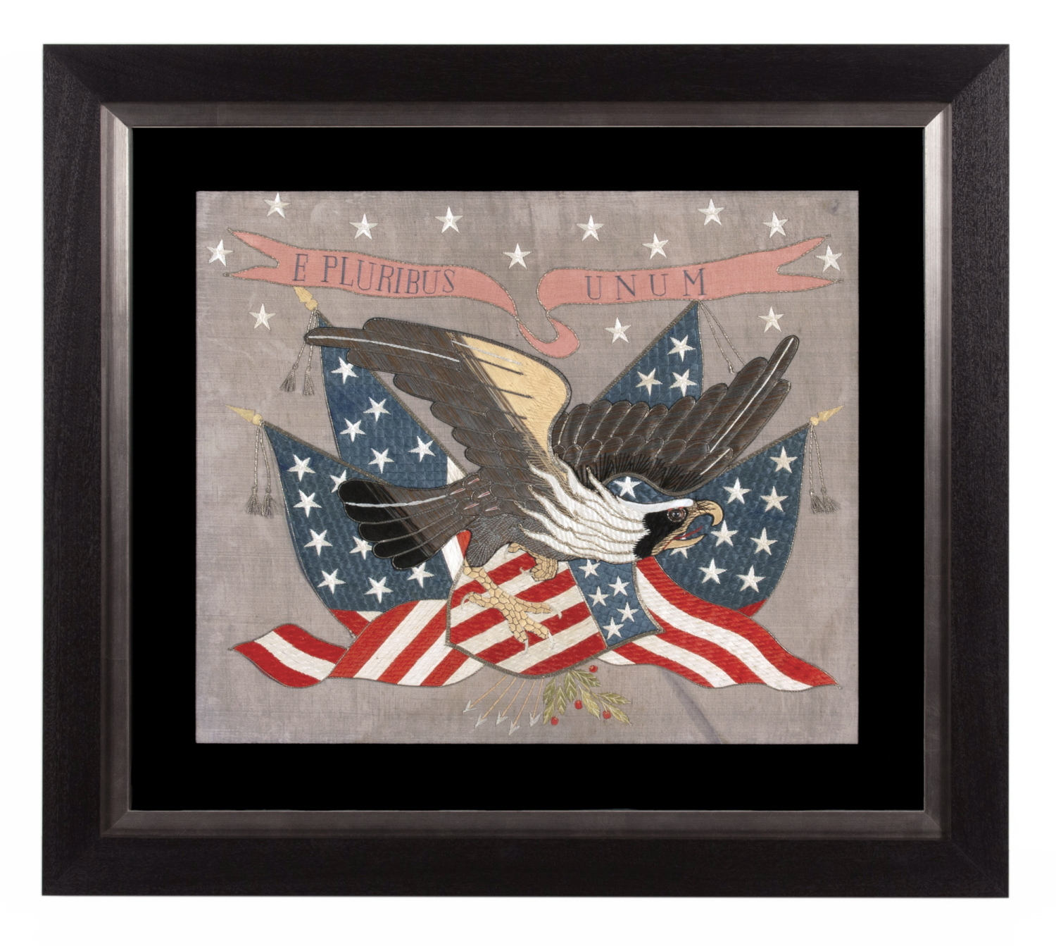 SAILOR’S SOUVENIR EMBROIDERY FROM THE WITH A FLYING, WARLIKE EAGLE SUPERIMPOSED ON A CANTED FEDERAL SHIELD & CROSSED AMERICAN FLAGS, BENEATH A STREAMER WITH THE LATIN MOTTO “E PLURIBUS UNUM,” INTERSPERSED WITH 13 STARS, circa 1890-1910