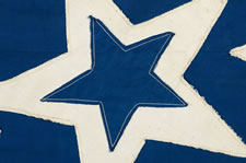 39 STARS IN A LINEAL PATTERN WITH A HUGE, HALOED CENTER STAR AND DYNAMIC VISUAL FEATURES, ITS CANTON RESTING ON THE WAR STRIPE, PROBABLY MADE FOR THE 1876 CENTENNIAL OF AMERICAN INDEPENDENCE, NEVER AN OFFICIAL STAR COUNT, REFLECTS THE ANTICIPATED ARRIVAL OF COLORADO AND THE DAKOTA TERRITORY