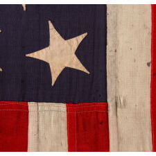13 HAND-SEWN STARS IN A 3-2-3-2-3 PATTERN ON AN ANTIQUE AMERICAN FLAG, A U.S. NAVY SMALL BOAT ENSIGN MADE AT MARE ISLAND, CALIFORNIA, HEADQUARTERS OF THE PACIFIC FLEET, SIGNED & DATED 1902