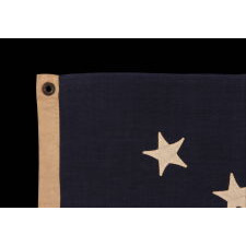 13 HAND-SEWN STARS IN A 3-2-3-2-3 PATTERN ON A U.S. NAVY SMALL BOAT ENSIGN OF THE CENTENNIAL ERA, MADE circa 1870-1882, IN A VARIANT OF THE SMALLEST REGULATION SIZE