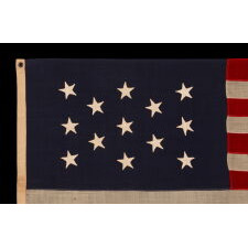 13 HAND-SEWN STARS IN A 3-2-3-2-3 PATTERN ON A U.S. NAVY SMALL BOAT ENSIGN OF THE CENTENNIAL ERA, MADE circa 1870-1882, IN A VARIANT OF THE SMALLEST REGULATION SIZE