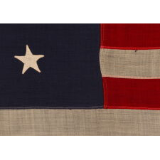 13 HAND-SEWN STARS IN A 3-2-3-2-3 PATTERN ON A U.S. NAVY SMALL BOAT ENSIGN OF THE CENTENNIAL ERA, MADE circa 1870-1882, IN A VARIANT OF THE SMALLEST REGULATION SIZE