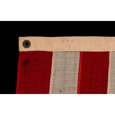 13 HAND-SEWN STARS IN A 3-2-3-2-3 PATTERN ON A U.S. NAVY SMALL BOAT ENSIGN OF THE CENTENNIAL ERA, MADE circa 1870-1882, IN A VARIANT OF THE SMALLEST REGULATION SIZE