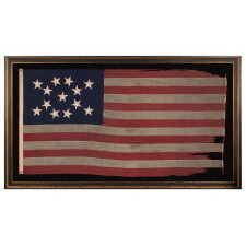 13 STAR ANTIQUE AMERICAN FLAG WITH HAND-SEWN STARS IN AN UNUSUAL, ELONGATED FORM OF THE MEDALLION CONFIGURATION AND ENDEARING WEAR FROM LONG-TERM USE, MADE IN THE ERA OF THE 1876 CENTENNIAL OF AMERICAN INDEPENDENCE