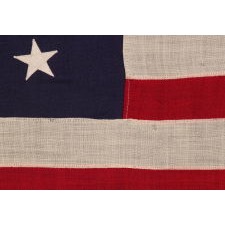13 STAR ANTIQUE AMERICAN FLAG WITH A BEAUTIFUL MEDALLION CONFIGURATION OF STARS; A SMALL-SCALE EXAMPLE, MADE CIRCA 1895-1926