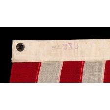 13 STAR ANTIQUE AMERICAN FLAG WITH A 3-2-3-2-3 CONFIGURATION OF STARS; A SMALL-SCALE EXAMPLE, MADE CIRCA 1895-1926, WITH AN OWNERSHIP STENCIL OF R.H. MACY & CO. ALONG THE HOIST