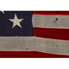 13 STAR ANTIQUE AMERICAN FLAG WITH A 3-2-3-2-3 CONFIGURATION OF STARS ON AN INDIGO CANTON, SQUARISH PROPORTIONS, AND A BEAUTIFUL OVERALL PRESENTATION, MADE circa 1895-1926