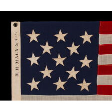 13 STAR ANTIQUE AMERICAN FLAG WITH A 3-2-3-2-3 CONFIGURATION OF STARS; A SMALL-SCALE EXAMPLE, MADE IN THE 1895-1926 ERA, MARKED “R.H. MACY & CO.”