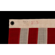 13 STAR ANTIQUE AMERICAN FLAG WITH A 3-2-3-2-3 CONFIGURATION OF STARS; A SMALL-SCALE EXAMPLE, MADE IN THE 1895-1926 ERA, MARKED “R.H. MACY & CO.”